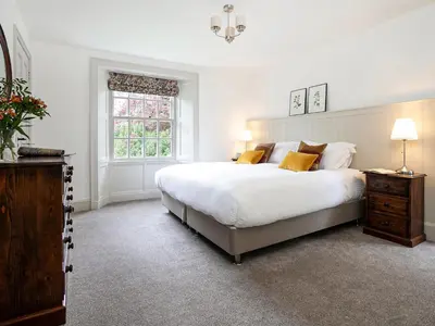 a bedroom with a large white bed and a window at Thorney How in Ambleside
