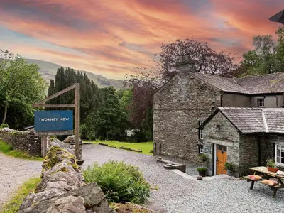 an old stone building with a sign in front of it at Thorney How in Ambleside