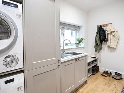 a kitchen with a sink and a washing machine at Little How in Ambleside
