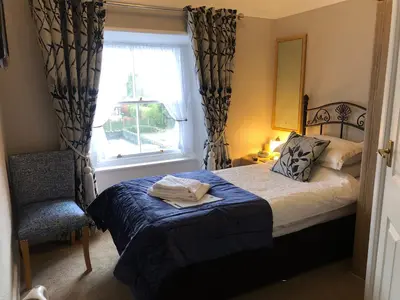 a bedroom with a bed and a window and a chair at Tarn Hows in Keswick