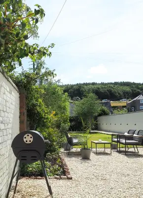 a patio with two chairs and a table and chairs at Coorie Away - Kirkcudbright in Kirkcudbright