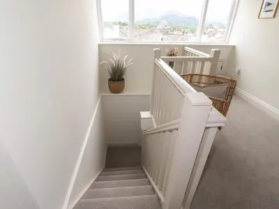 a white staircase in a room with a window at Fran's Nest in Keswick