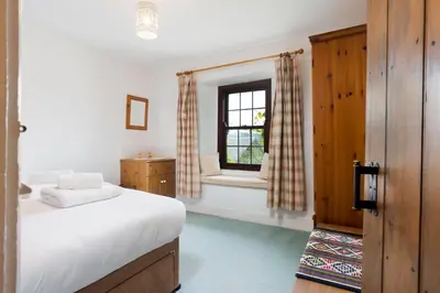 a bedroom with a bed and a window at Old Sawpit in Ambleside