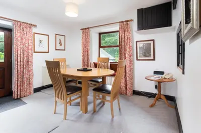 a dining room with a wooden table and chairs at Old Sawpit in Ambleside