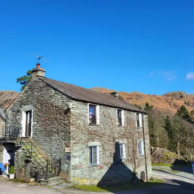 an old stone house with a chimney on top of it at Old Sawpit in Ambleside