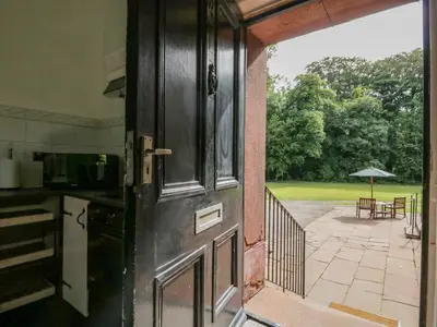an open door leading to a patio with an umbrella at The Residence in Cleator