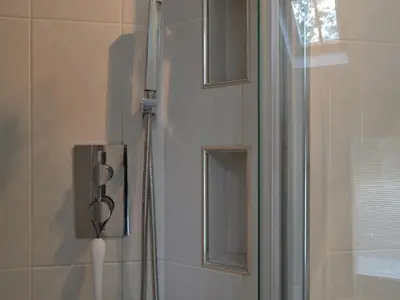 a shower in a bathroom next to a window at 4 Harney Peak in Portinscale