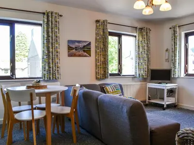 a living room with a couch and a table at Buttermere Apartment in Keswick
