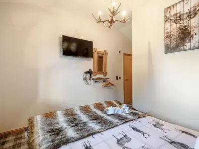 a bedroom with a bed and a tv on a wall at Appletree Lodge in Ayr
