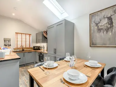 a dining room with a wooden table and chairs at Appletree Lodge in Ayr