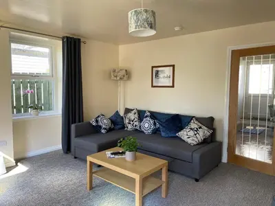 a living room with a couch and a table at Cozy 2 bedroom cottage with log burner close to Loch Ken in New Galloway