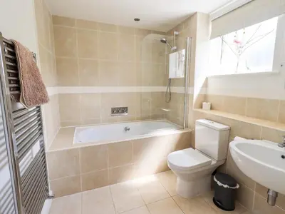 a bathroom with a tub and a toilet and a sink at Fell Sweep in Keswick