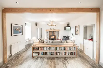 a living room with a couch and a book shelf at Diamonds Laggan in Castle Douglas