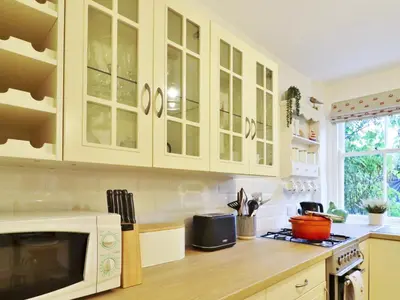 a kitchen with white cabinets and a microwave at Union Street in Kirkcudbright