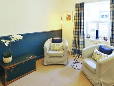 a living room with two chairs and a table at Union Street in Kirkcudbright