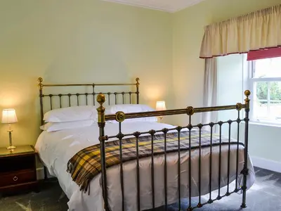 a bedroom with a bed and a window at Craigvar House in Castle Douglas