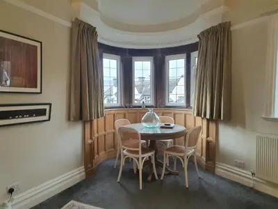 a dining room with a table and chairs and windows at Grandy Nook in Keswick