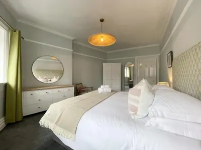 a bedroom with a large white bed and a mirror at Grandy Nook in Keswick