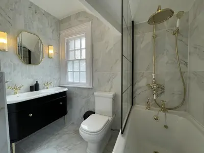 a bathroom with a toilet and a tub and a sink at Shelley Cottage in Keswick