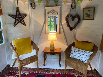 a room with two chairs and a table with a lamp at Shelley Cottage in Keswick