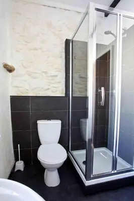 a bathroom with a toilet and a glass shower at Cragside Cottage in Troutbeck