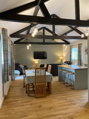 a dining room and kitchen with a table and chairs at Cragside Cottage in Troutbeck