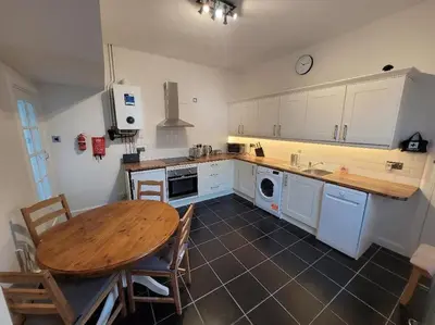 a kitchen with a wooden table and a table and chairs at Character cottage in centre of Moffat in Moffat