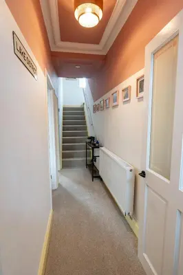 a hallway with stairs and a ceiling with a light at Daffodil House in Cockermouth