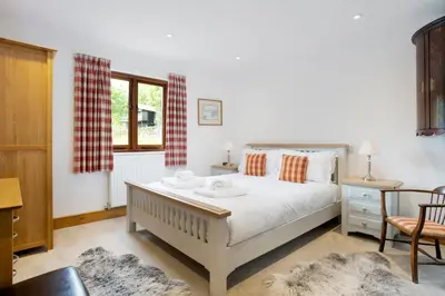 a bedroom with a large bed and a window at Keiras Cottage in Ambleside