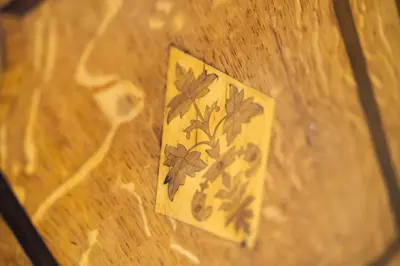 a tile with a flower design on a wooden floor at Keiras Cottage in Ambleside