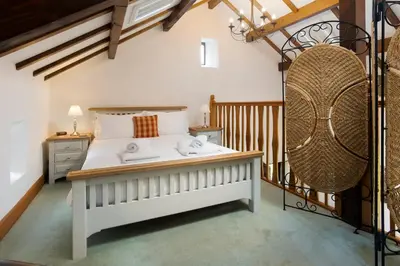 a bedroom with a large white bed in a room at Keiras Cottage in Ambleside
