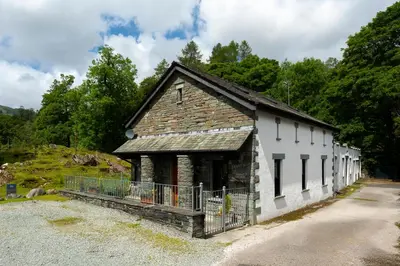 a small white building with a roof at Keiras Cottage in Ambleside