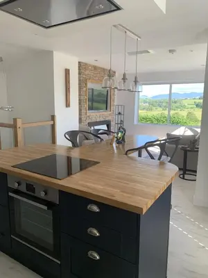 a kitchen with a island with a wooden counter top at Luxury Cottage, views of the Lakes with Hot Tub in Cockermouth