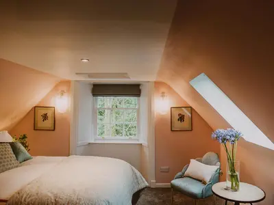 a attic bedroom with a bed and a window at Fawn's Velvet in Enoch