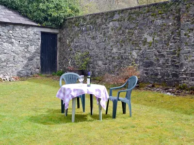 two chairs and a table with a table cloth on it at Gardener's Cottage in Palnure