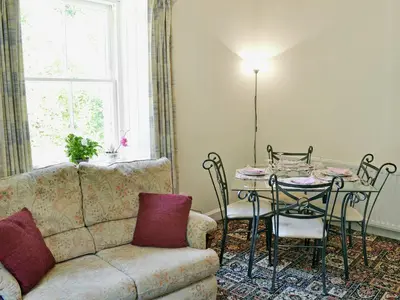 a living room with a couch and a table at Gardener's Cottage in Palnure
