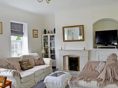 a living room with a couch and a fireplace at Coastguard's Cottage in Carsethorn
