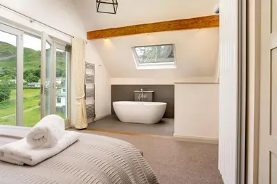 a bedroom with a bath tub and a bed at Lowfield House in Ambleside