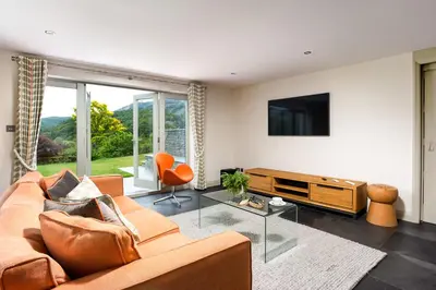 a living room with a couch and a flat screen tv at Lowfield House in Ambleside