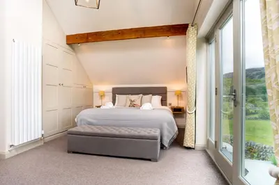 a bedroom with a bed and a large window at Lowfield House in Ambleside