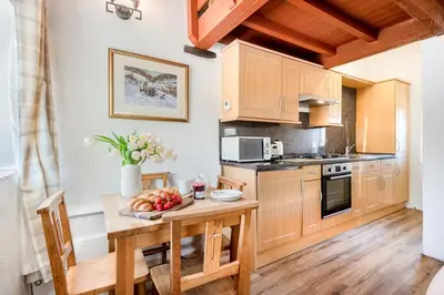 a kitchen with a table with a bowl of fruit on it at Cottage 1, Old Farmhouse Mews in Braithwaite