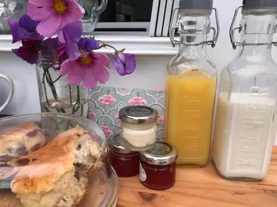 a table with jars of honey and a plate of food at Mill Cottage modern cosy Lake District home with open fire near Scafell in Gosforth