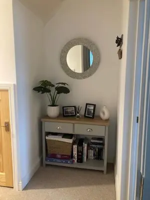 a table with a mirror and a shelf with books at Marni’s Cottage - Rural location & fell views in Frizington