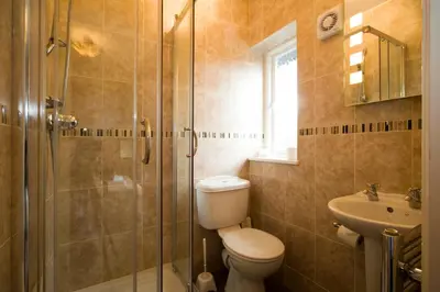 a bathroom with a toilet and a shower and a sink at Dalegarth House Portinscale in Keswick