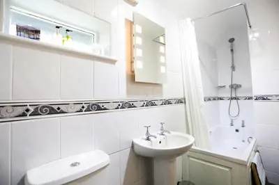 a white bathroom with a sink and a mirror at Dalegarth House Portinscale in Keswick