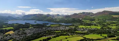 an aerial view of a town with a lake and mountains at Dalegarth House Portinscale in Keswick