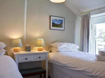 a bedroom with two beds and a window at Hey Down in Keswick