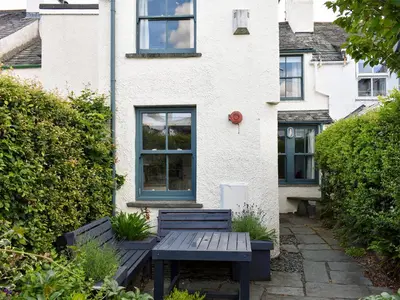 a table and benches in front of a house at Hey Down in Keswick