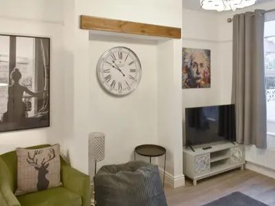 a living room with a clock and a tv at Helvellyn House in Keswick
