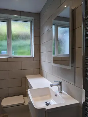 a bathroom with a sink and two windows at Three Peaks in Braithwaite